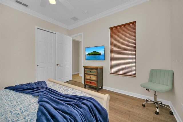 bedroom featuring a closet, hardwood / wood-style flooring, ceiling fan, and ornamental molding