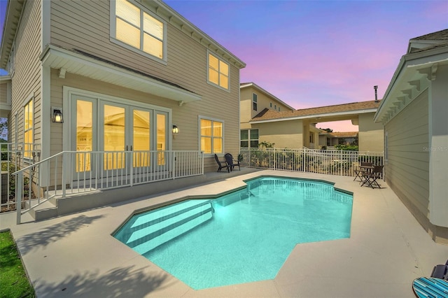 pool at dusk featuring a patio area