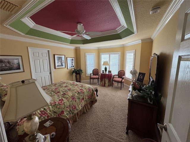 carpeted bedroom featuring ceiling fan, ornamental molding, a raised ceiling, and a textured ceiling