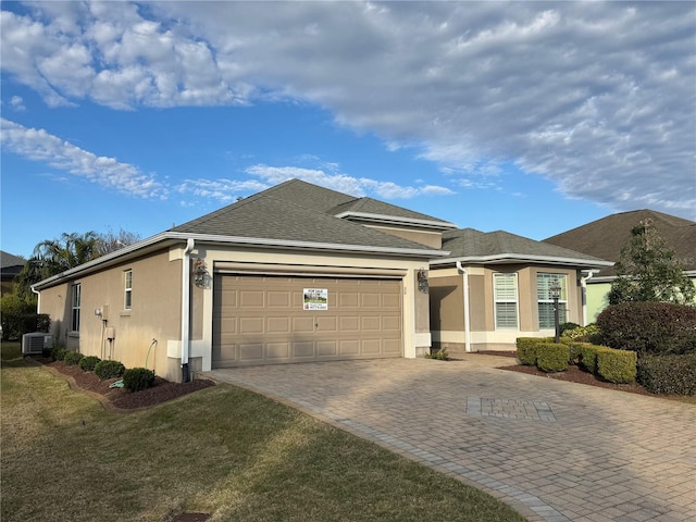 single story home featuring a garage and a front lawn