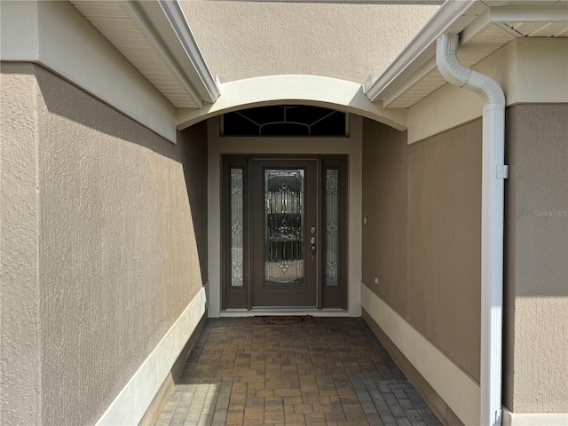 property entrance with stucco siding