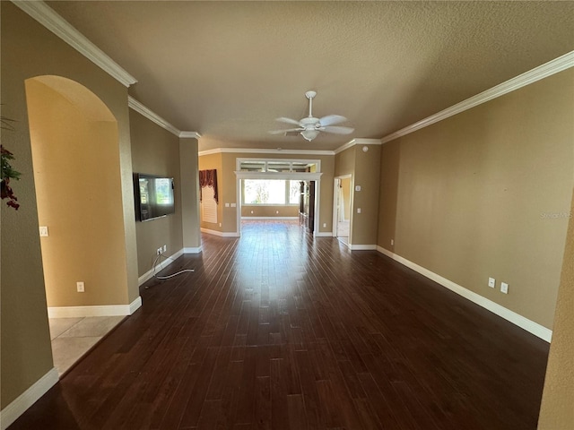 interior space featuring baseboards, arched walkways, a ceiling fan, wood finished floors, and crown molding