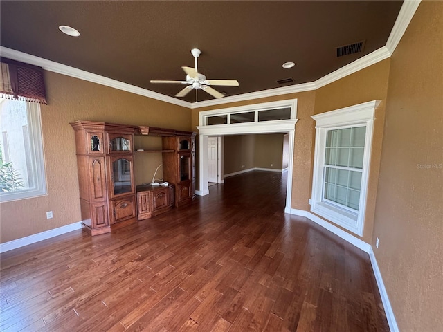 unfurnished living room featuring ornamental molding, dark wood finished floors, visible vents, and baseboards