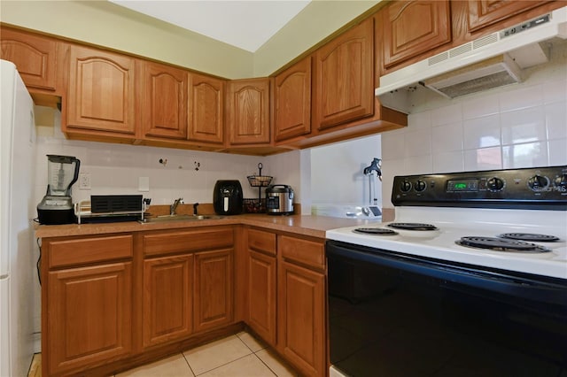 kitchen featuring light tile patterned floors, white appliances, tasteful backsplash, and sink