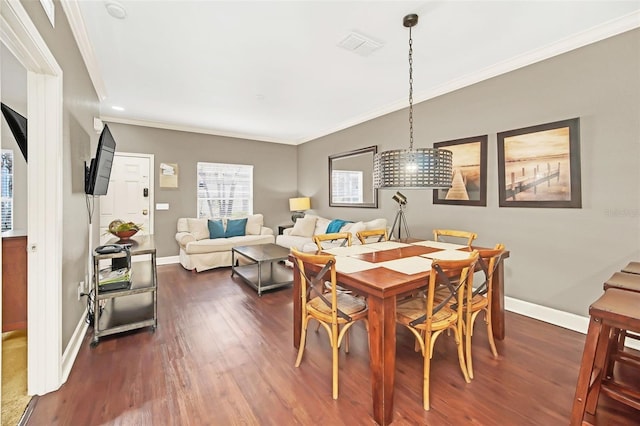 dining space with crown molding and dark hardwood / wood-style flooring