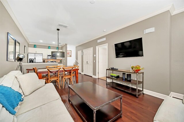 living room with dark hardwood / wood-style flooring and ornamental molding