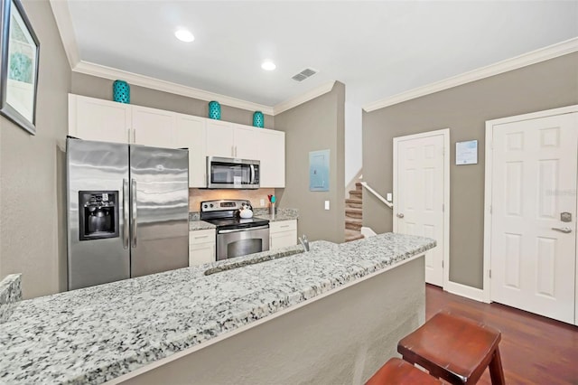 kitchen with white cabinets, a kitchen breakfast bar, sink, light stone countertops, and stainless steel appliances