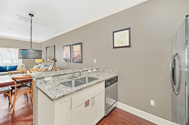 kitchen with light stone countertops, appliances with stainless steel finishes, kitchen peninsula, pendant lighting, and white cabinetry