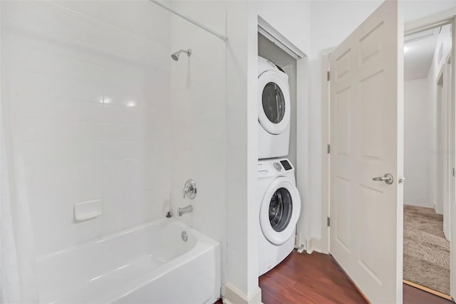 laundry area featuring dark hardwood / wood-style flooring and stacked washer and clothes dryer