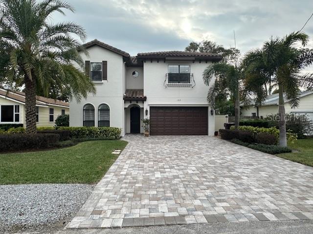 mediterranean / spanish house featuring a garage and a front yard