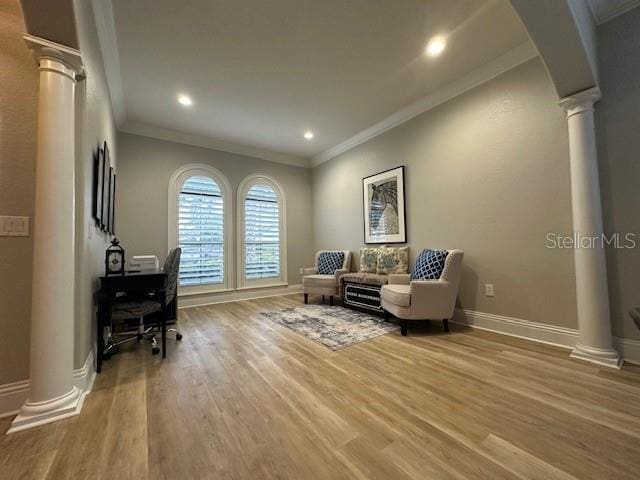 office area with ornate columns, wood-type flooring, and ornamental molding