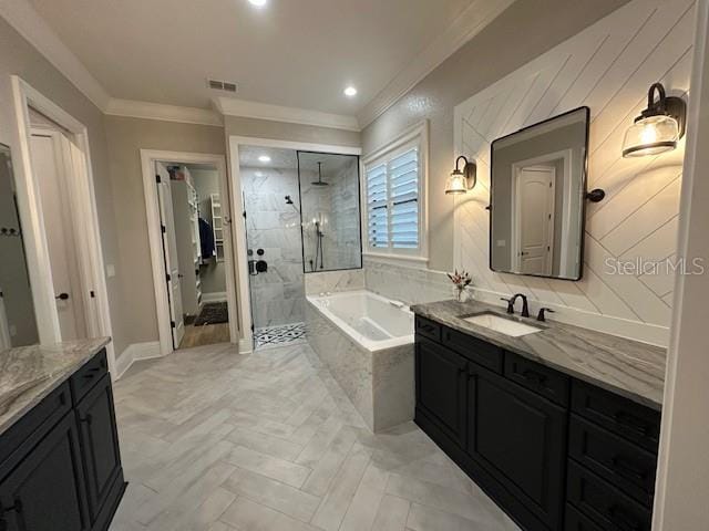 bathroom with plus walk in shower, vanity, and ornamental molding