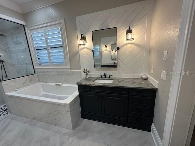 bathroom with a relaxing tiled tub, crown molding, and vanity