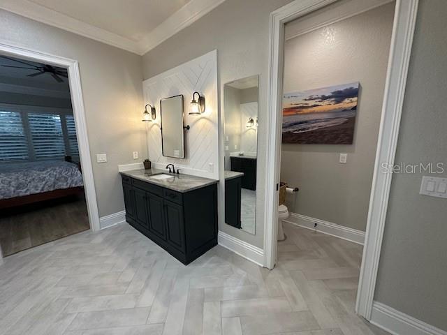 bathroom with vanity, toilet, parquet floors, and crown molding