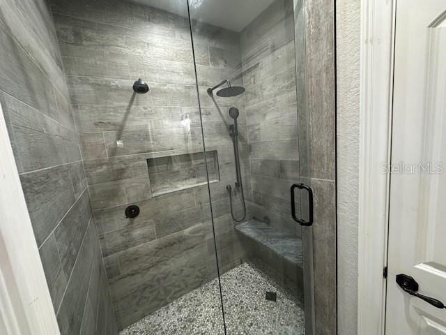 bathroom with a shower with door