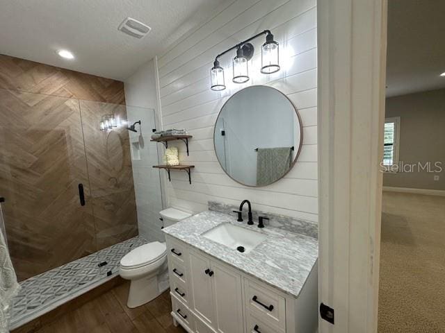 bathroom with an enclosed shower, vanity, toilet, and hardwood / wood-style flooring