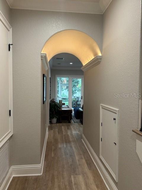 corridor with hardwood / wood-style floors and crown molding