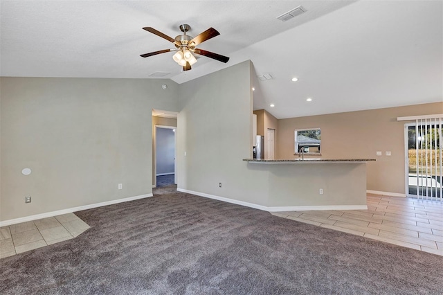 unfurnished living room featuring light colored carpet, ceiling fan, and vaulted ceiling