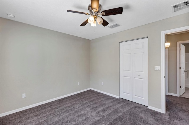 unfurnished bedroom with a closet, ceiling fan, and dark carpet