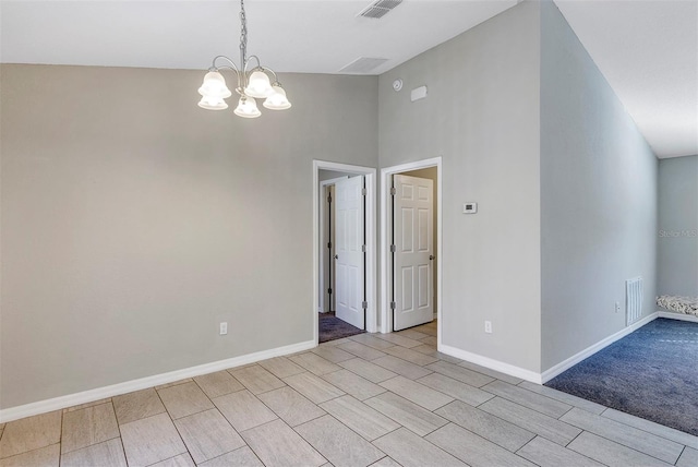 unfurnished room with a notable chandelier and high vaulted ceiling