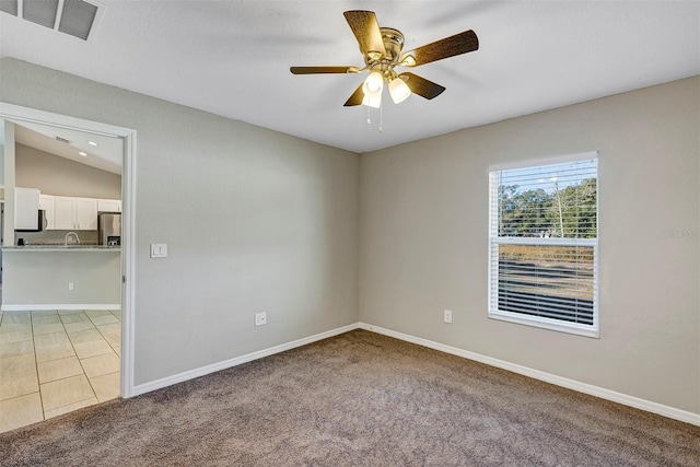 carpeted empty room featuring ceiling fan and vaulted ceiling