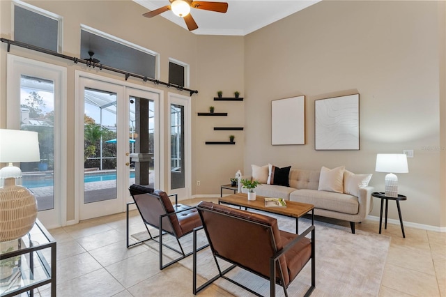 tiled living room with ceiling fan and ornamental molding