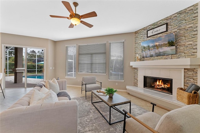 tiled living room featuring ceiling fan and a fireplace