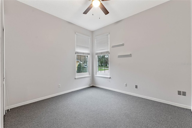 empty room with ceiling fan and dark colored carpet