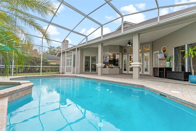 view of swimming pool with ceiling fan, a lanai, and a patio