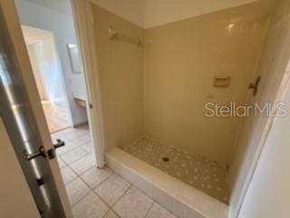 bathroom with a stall shower and tile patterned floors