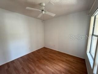 spare room featuring ceiling fan and dark wood-style flooring