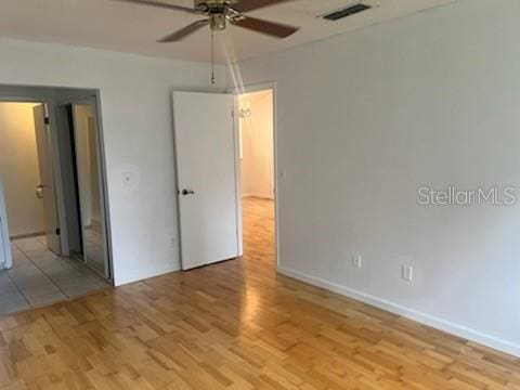 unfurnished bedroom with ceiling fan, light wood-type flooring, visible vents, and baseboards