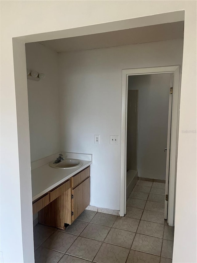 bathroom featuring tile patterned flooring, baseboards, and vanity