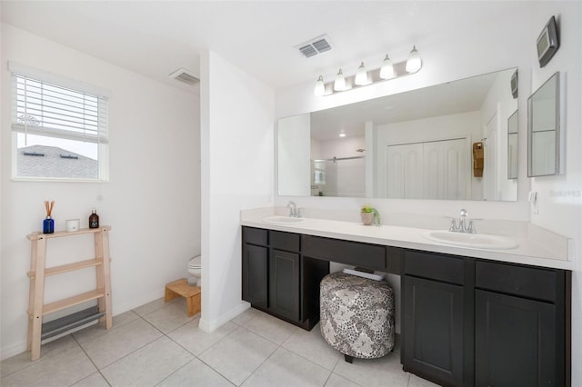 bathroom with tile patterned floors, vanity, toilet, and walk in shower