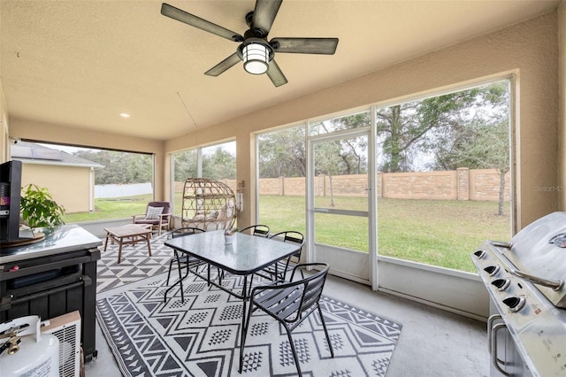 sunroom / solarium featuring a healthy amount of sunlight and ceiling fan