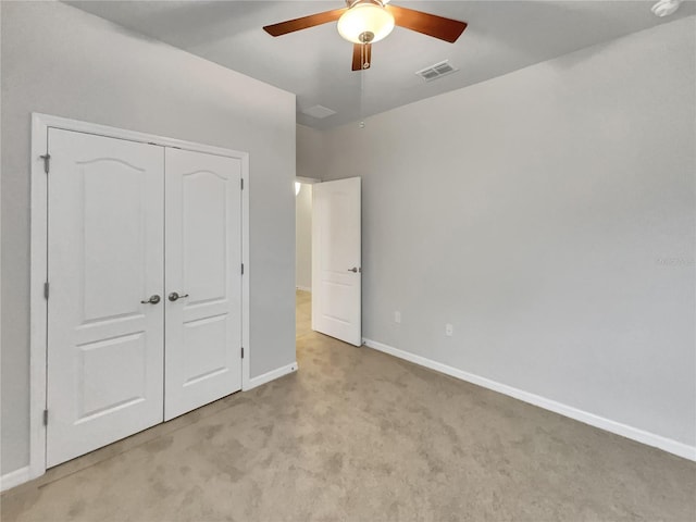 unfurnished bedroom with light carpet, a closet, and ceiling fan