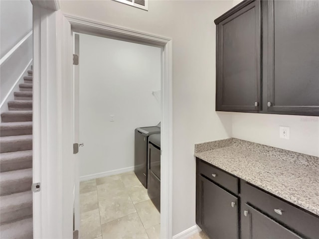 laundry area featuring washing machine and dryer and light tile patterned flooring