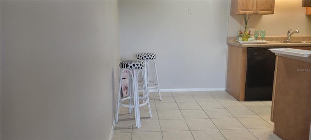 kitchen featuring light tile patterned floors, dishwasher, and sink