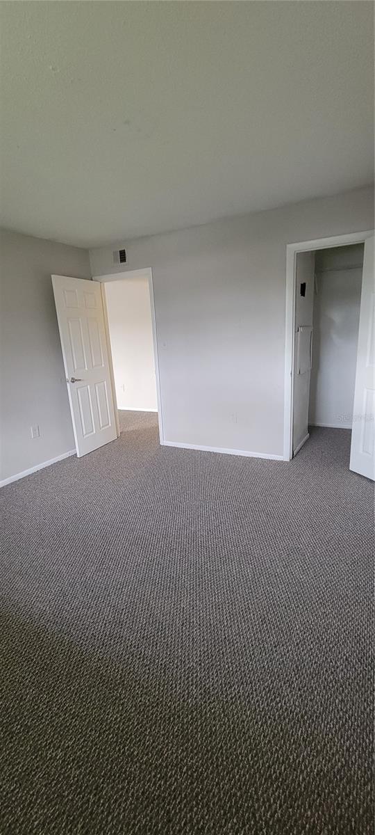 unfurnished room with dark colored carpet