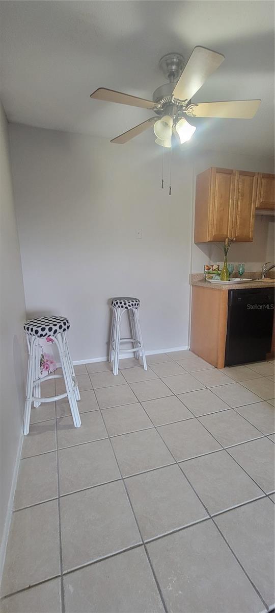 kitchen with light tile patterned floors, dishwasher, and sink