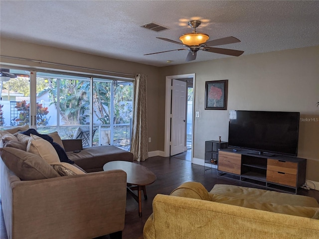 living room with ceiling fan, dark hardwood / wood-style floors, and a textured ceiling