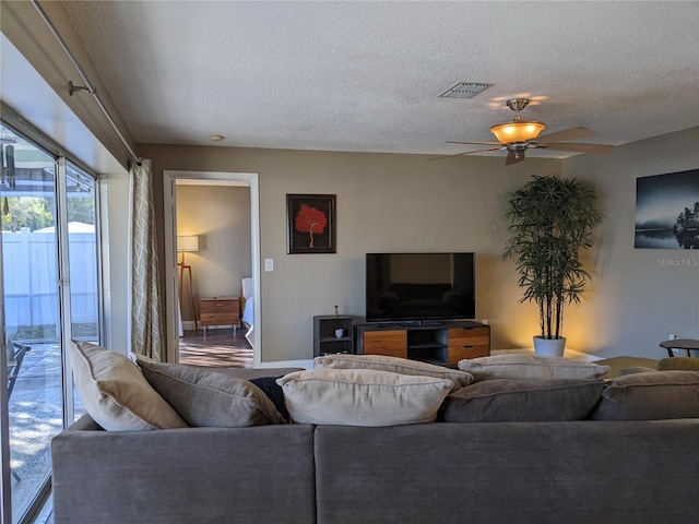 living room featuring a textured ceiling and ceiling fan