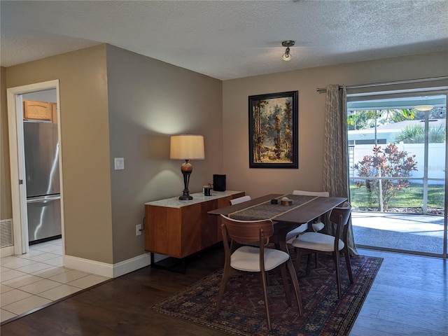 home office with a textured ceiling and light hardwood / wood-style flooring