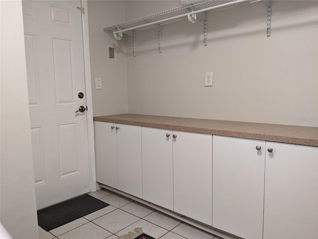 laundry area with light tile patterned floors