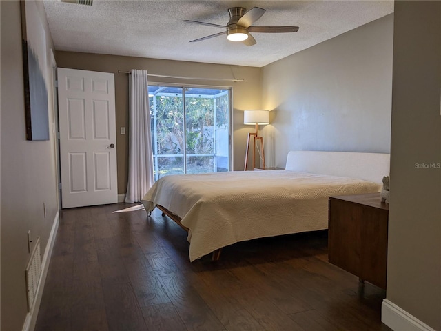 bedroom with ceiling fan, dark hardwood / wood-style flooring, and a textured ceiling