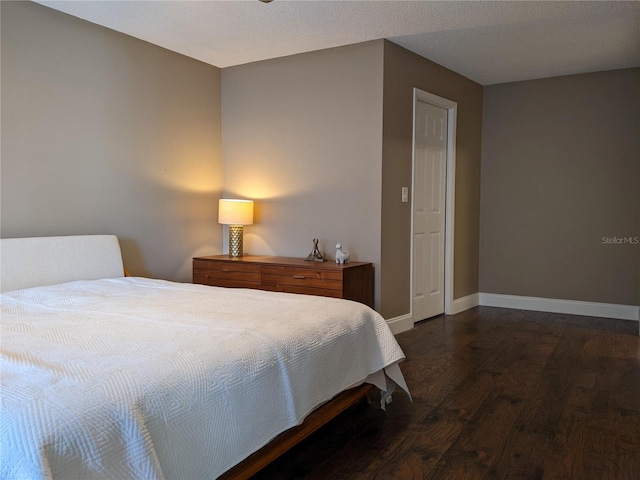 bedroom featuring dark hardwood / wood-style floors and a textured ceiling