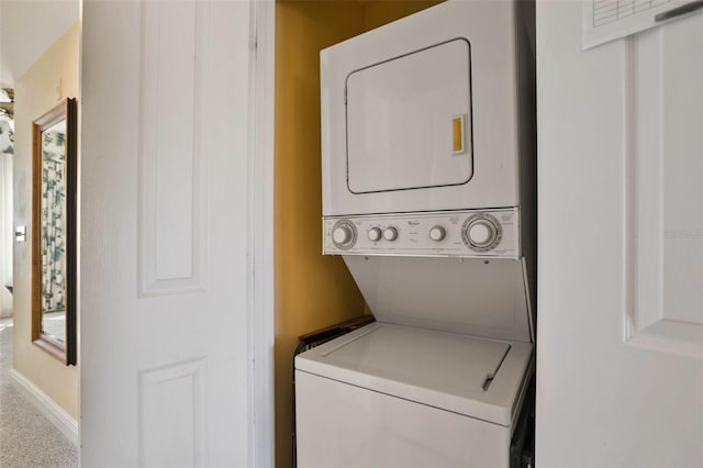 clothes washing area with stacked washer / dryer