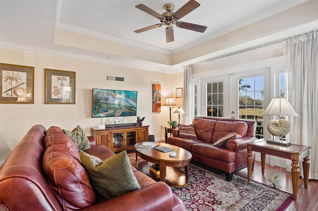 living room with french doors, crown molding, wood-type flooring, a tray ceiling, and ceiling fan