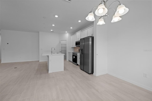 kitchen with a sink, open floor plan, electric stove, black fridge, and stainless steel microwave