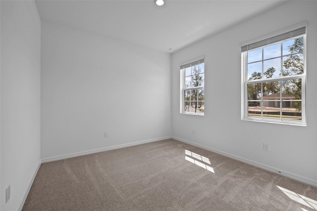 carpeted spare room featuring baseboards